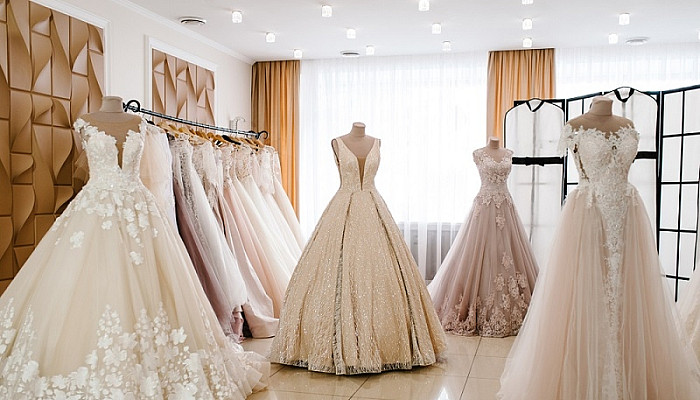 bridal dress hanging on hangers and mannequin in studio