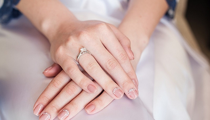 Bride hand on wedding dress