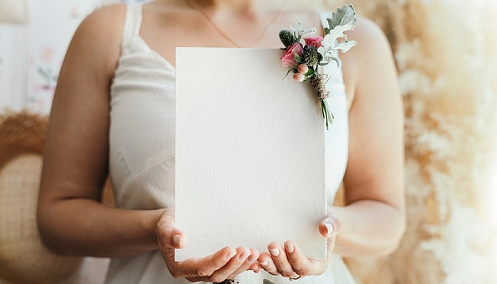 Bride holding a blank white Invitation card