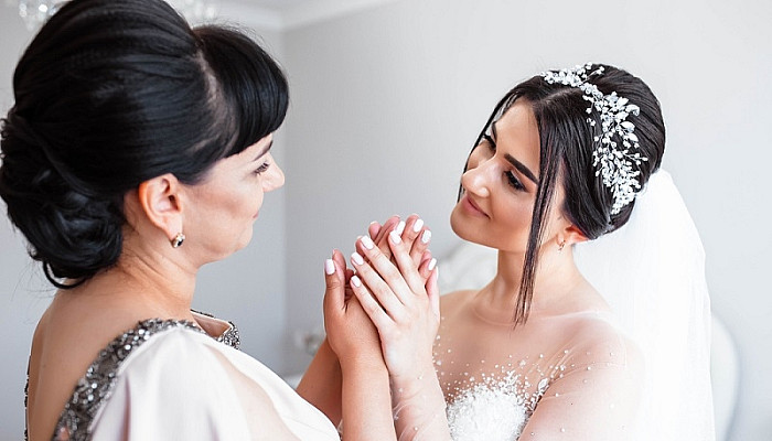 Bride holding her mother's hands on the wedding day