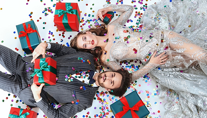 Couple lie on the floor surrounded by gifts 