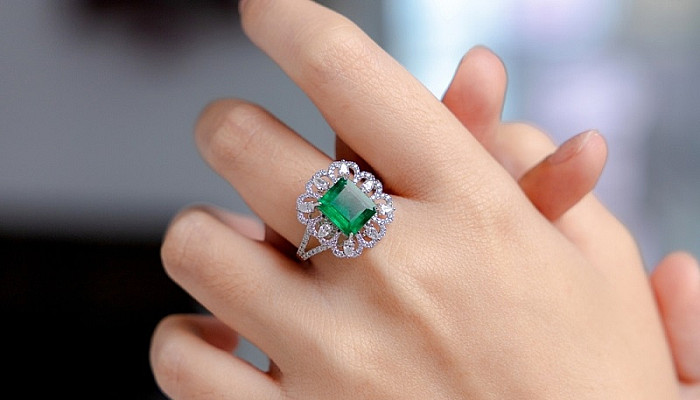 Emerald ring on the finger of a woman