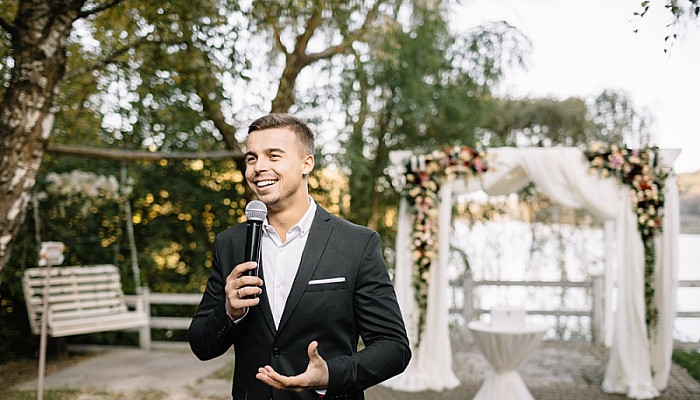 Elegant man with a microphone talking speech at a wedding