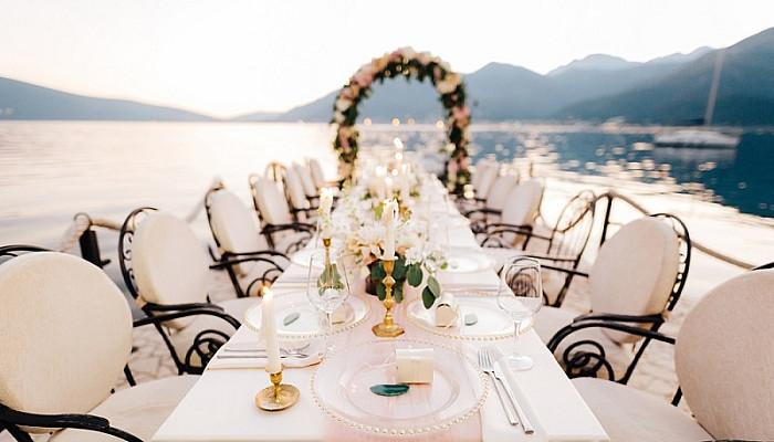 wedding dinner table with chairs, burning candles, wedding arch 