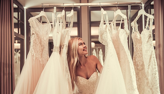 young bride is smiling while choosing wedding dress