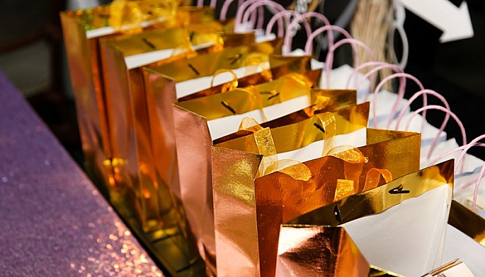 several golden goodie bags on a table