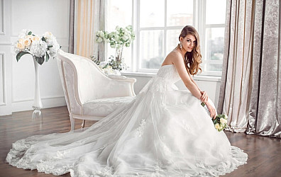 Bride in beautiful dress sitting on sofa