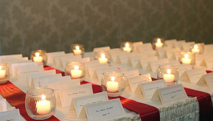 small candles lighting Escort cards for guests at a wedding reception
