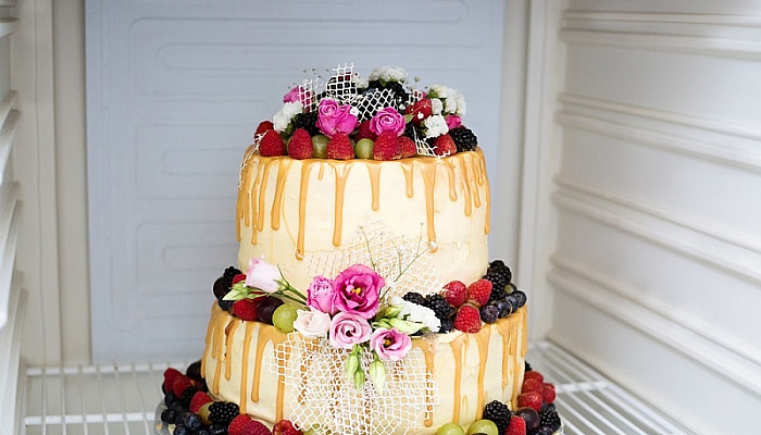two layers white cream and fruit wedding cake stored inside a fridge