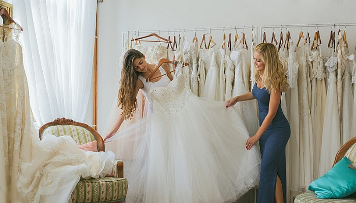 Women choosing wedding dress in bridal flagship
